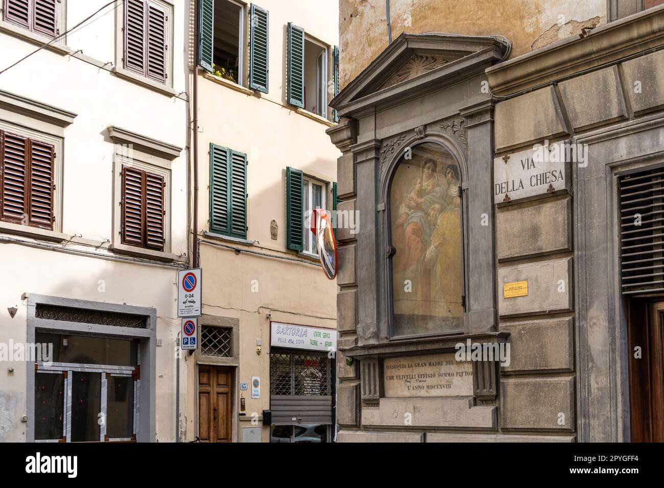 Tabernacle with Holy Mary and plaque pointing 'Via della Chiesa', picturesque street in Florence city center, San Frediano neighborhood, Tuscany regio Stock Photo