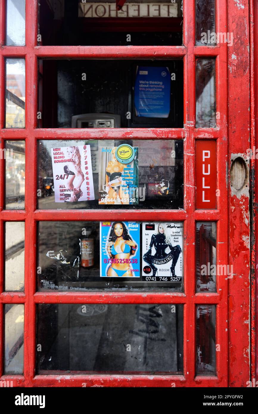 Cards stuck on a London telephone booth offering personal services Stock Photo
