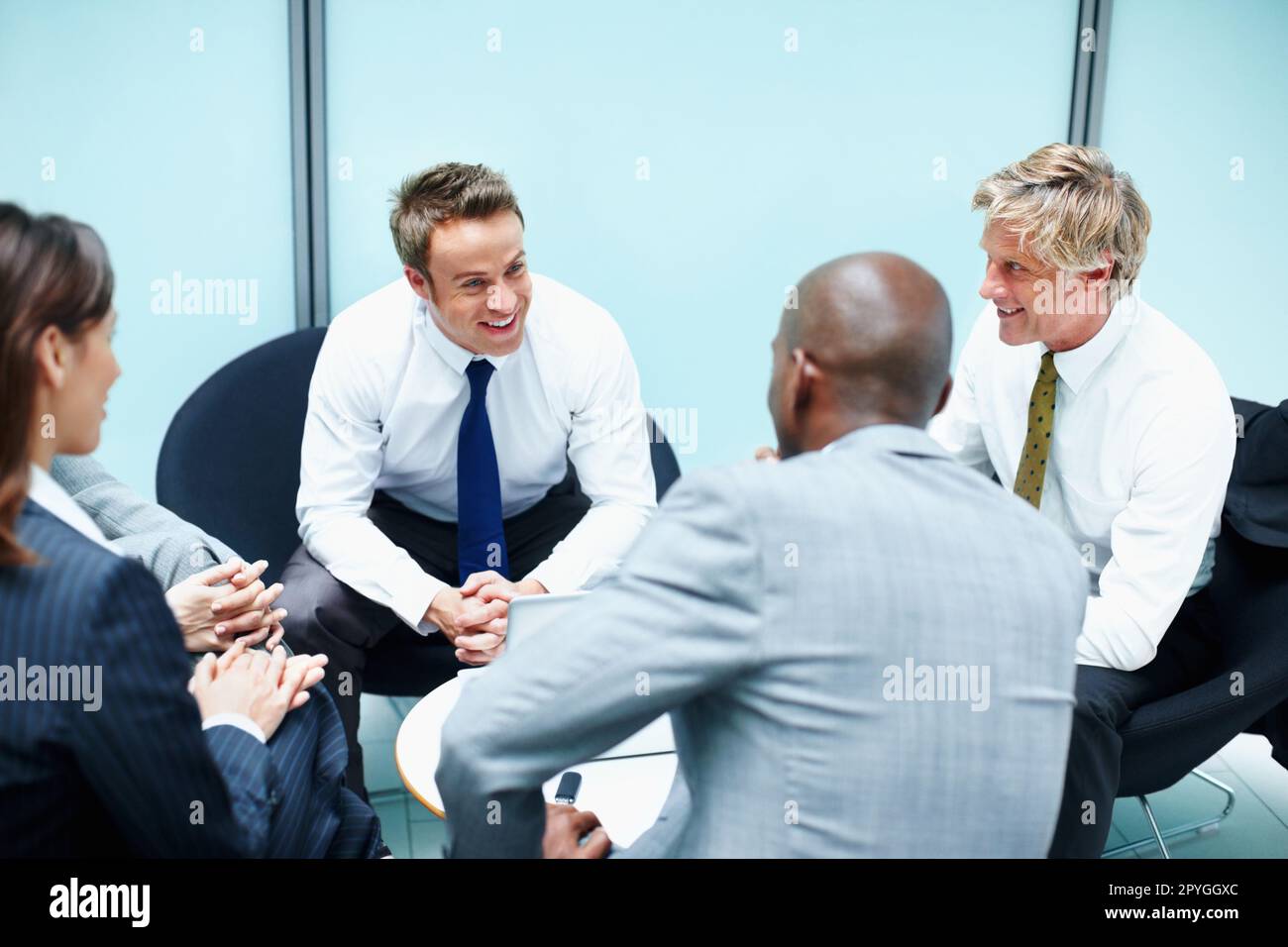 Happy business people discussing. Portrait of happy multi racial business people discussing in office. Stock Photo