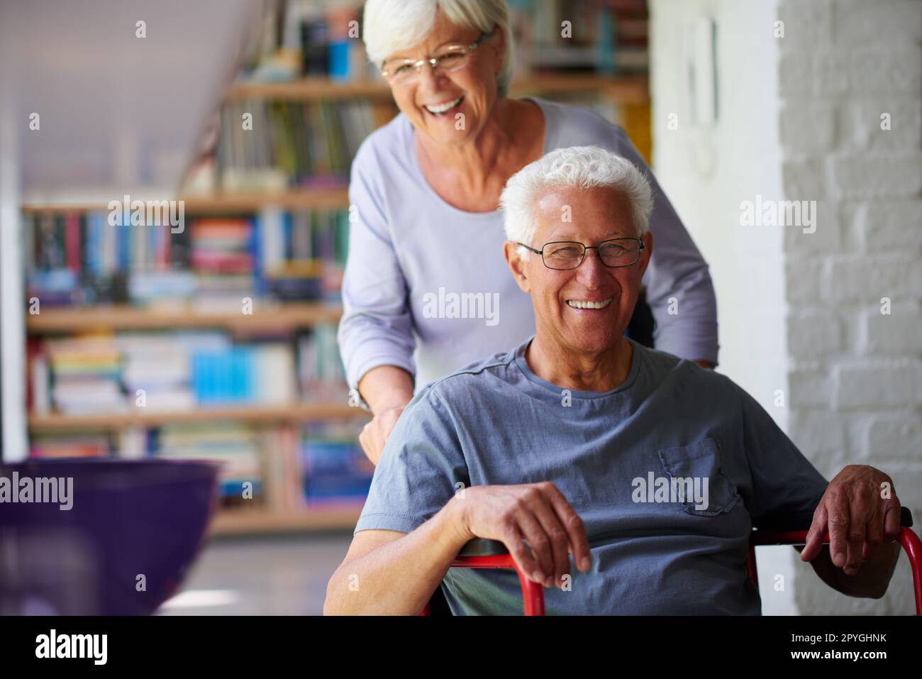 Our lives are full of joy. Portrait of a happy senior man in a wheelchair being helped by his wife. Stock Photo