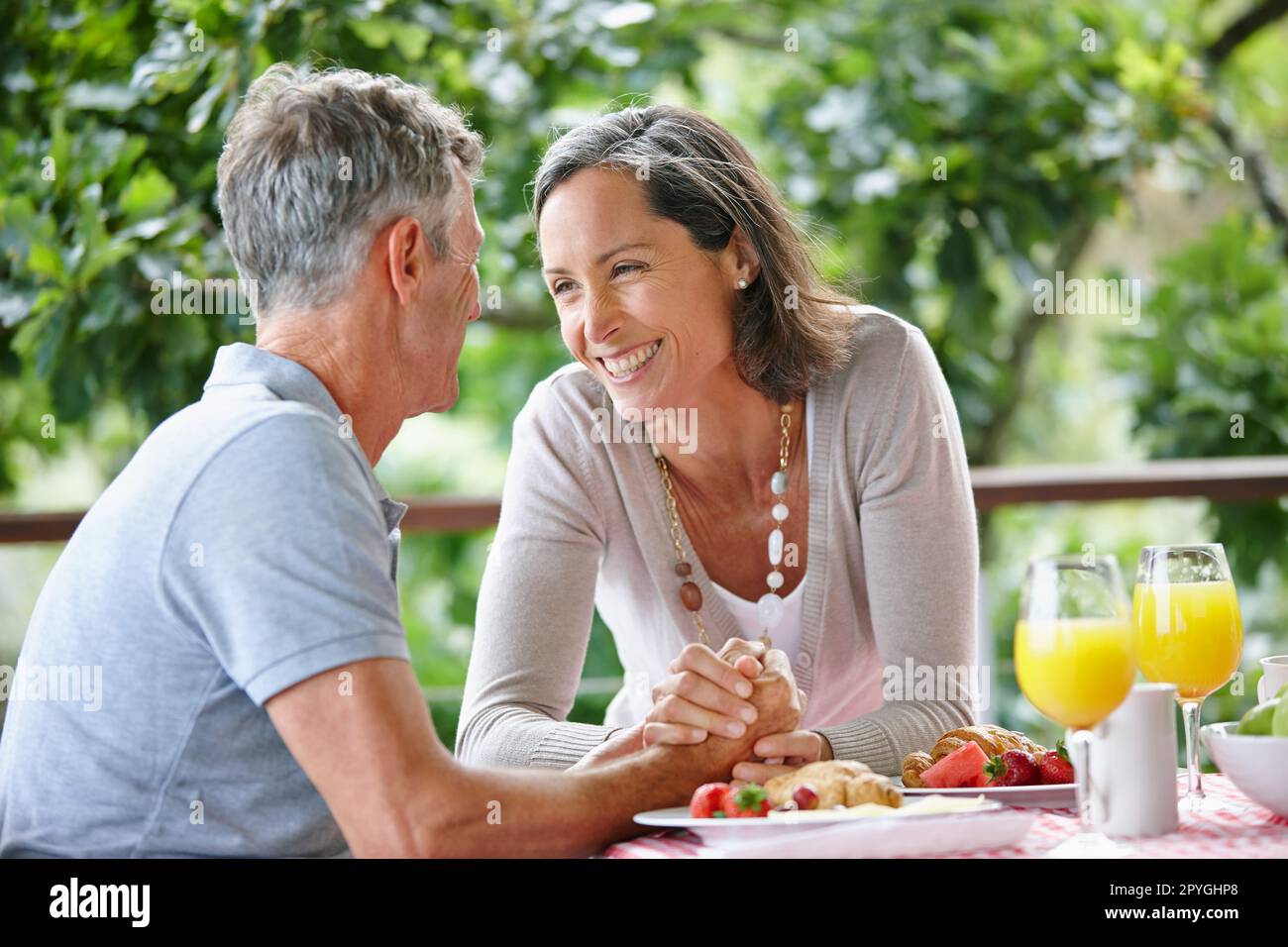 They bring each other joy. a mature couple bonding while having breakfast together outdoors. Stock Photo