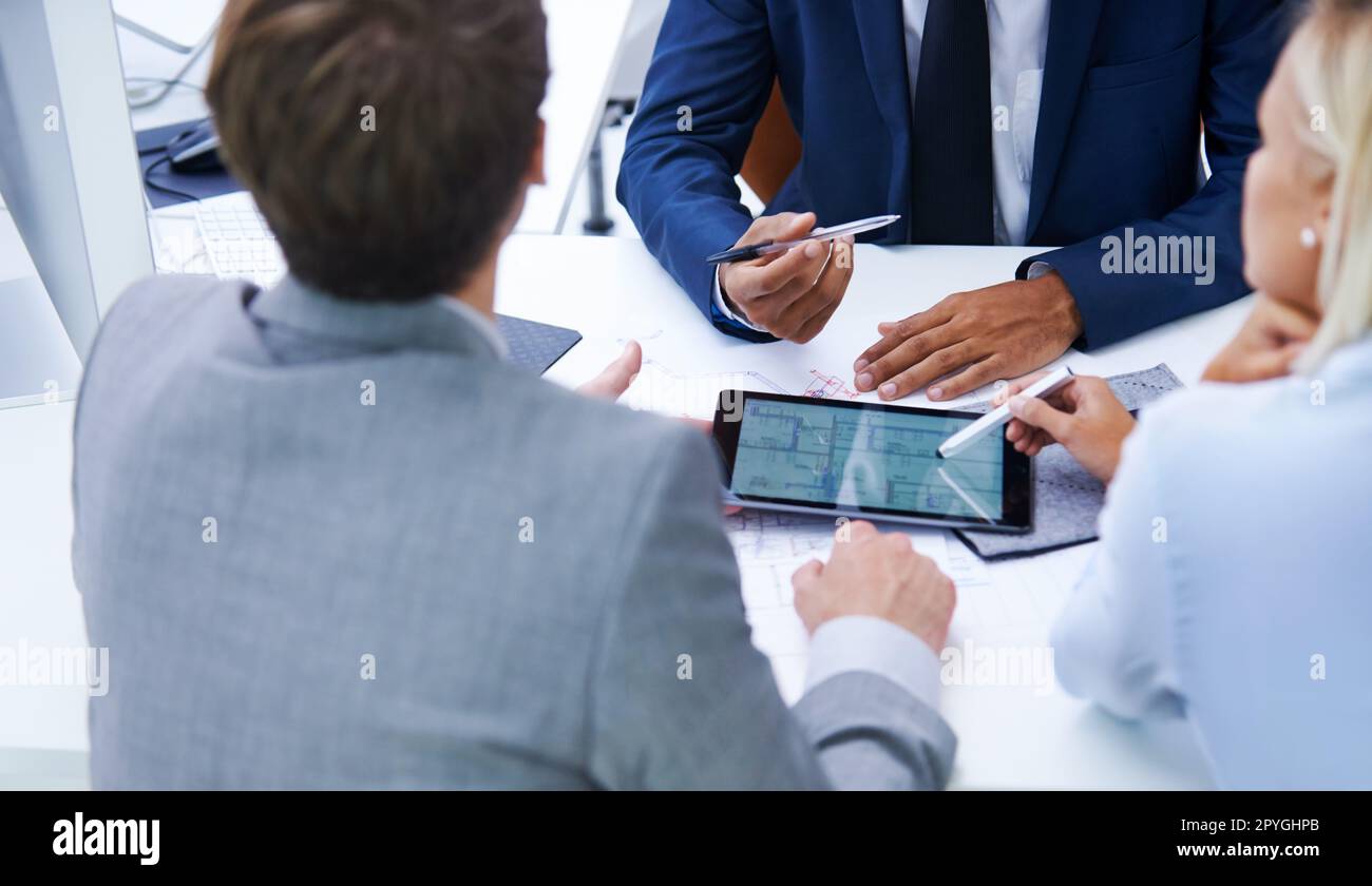 Getting down to the details. businesspeople discussing plans on a digital tablet. Stock Photo