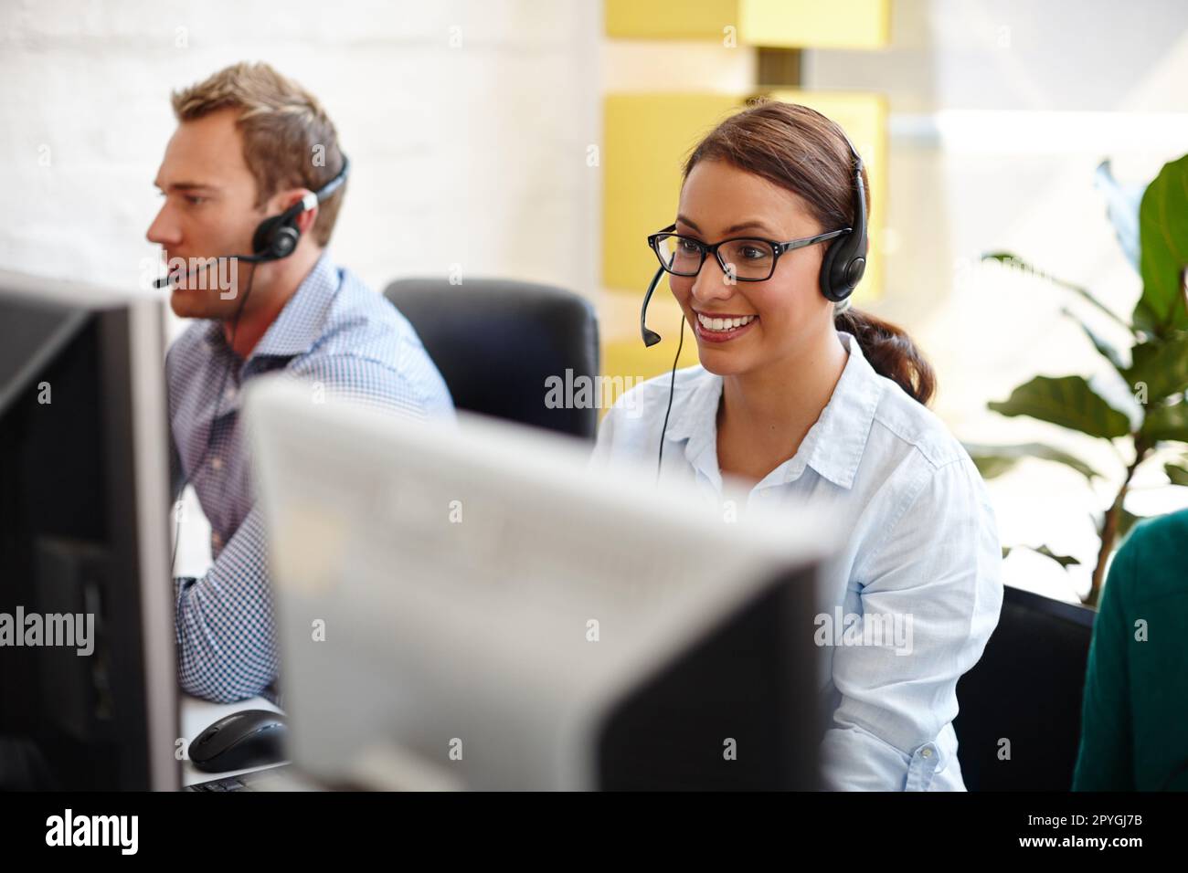 They know how to deal with every sort of client. customer service representatives taking calls in their office. Stock Photo