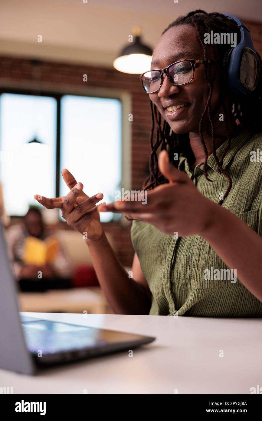 Portrait of student with wireless headphones talking casual in video ...
