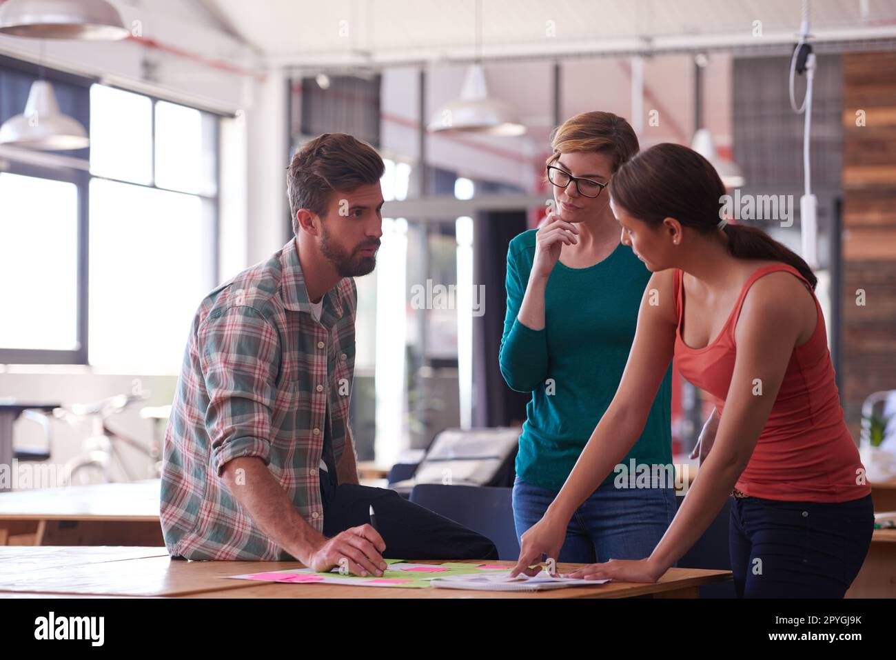 Teamwork makes the dream work. a group of young creatives talking around a table. Stock Photo