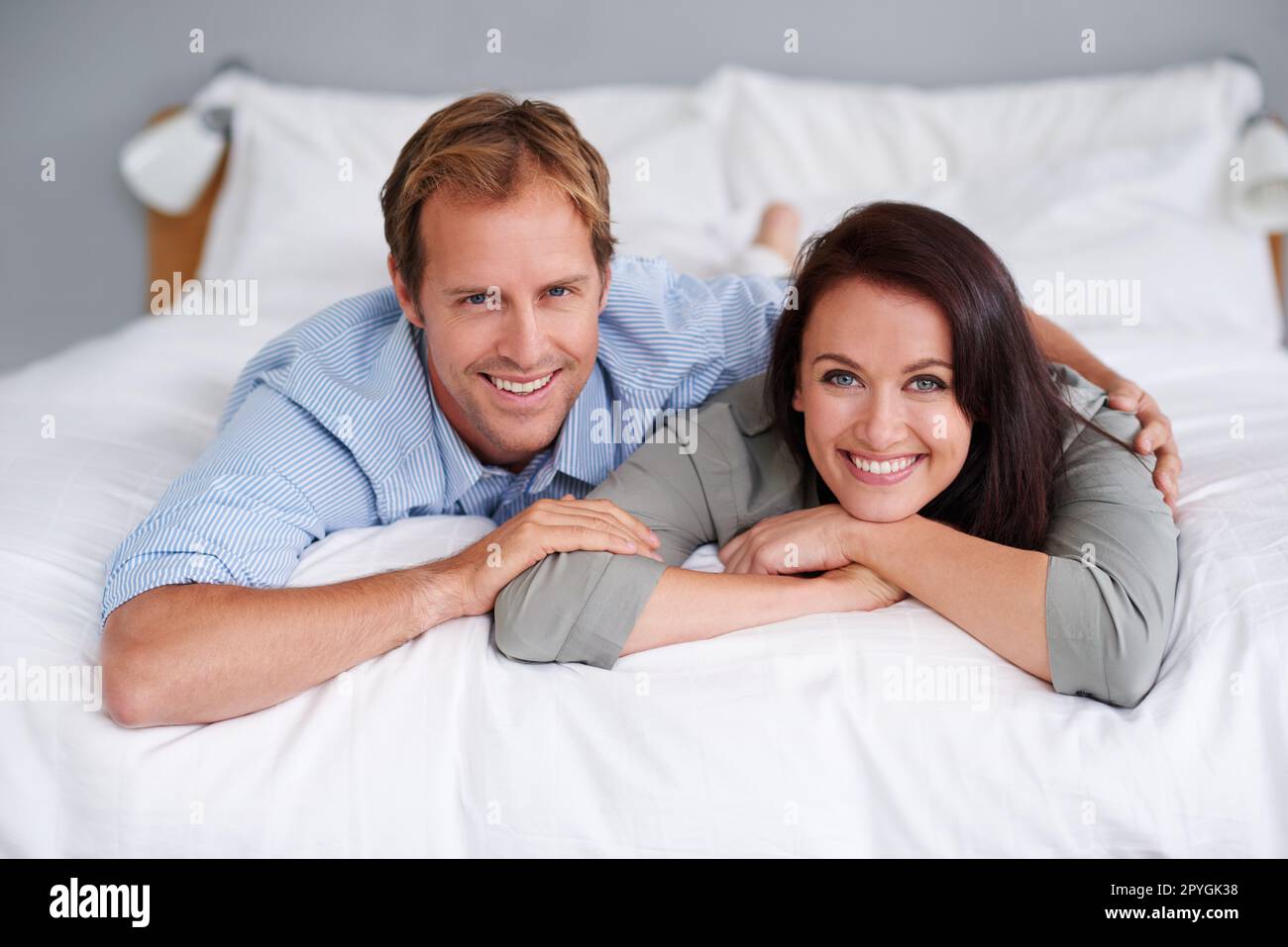 The weekend menu Rest and relaxation. Portrait of a happy young couple lying on their bed at home. Stock Photo
