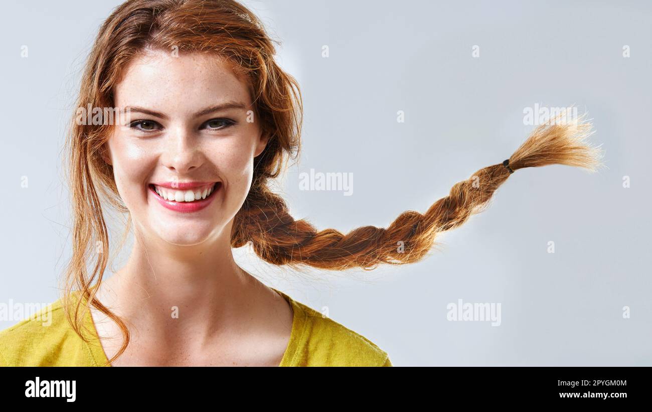 Pure joy. Cropped studio portrait of a happy and beautiful young woman with braided hair. Stock Photo