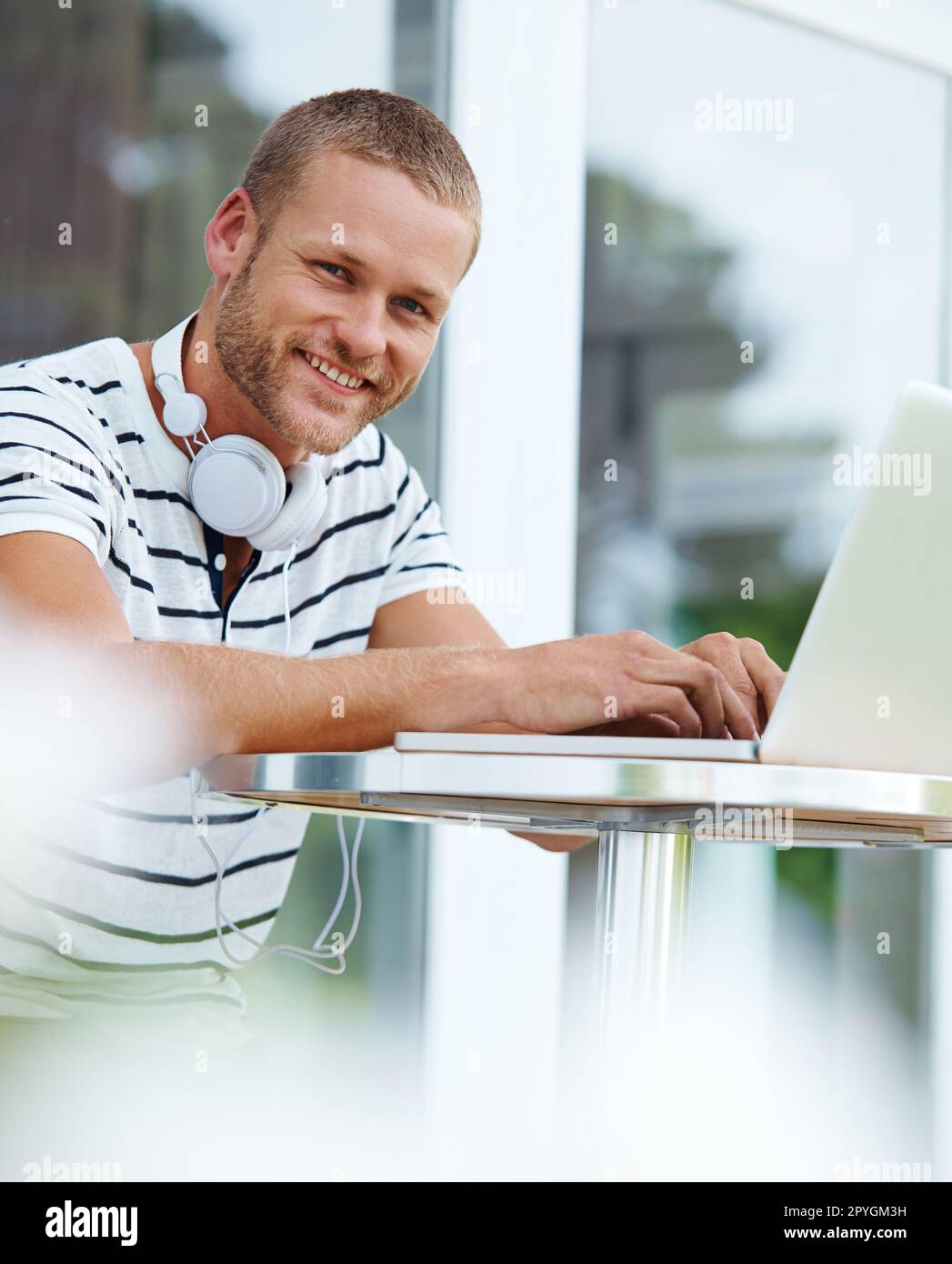 Taking his work wherever he may go. Portrait of a handsome young man working outside on a laptop. Stock Photo