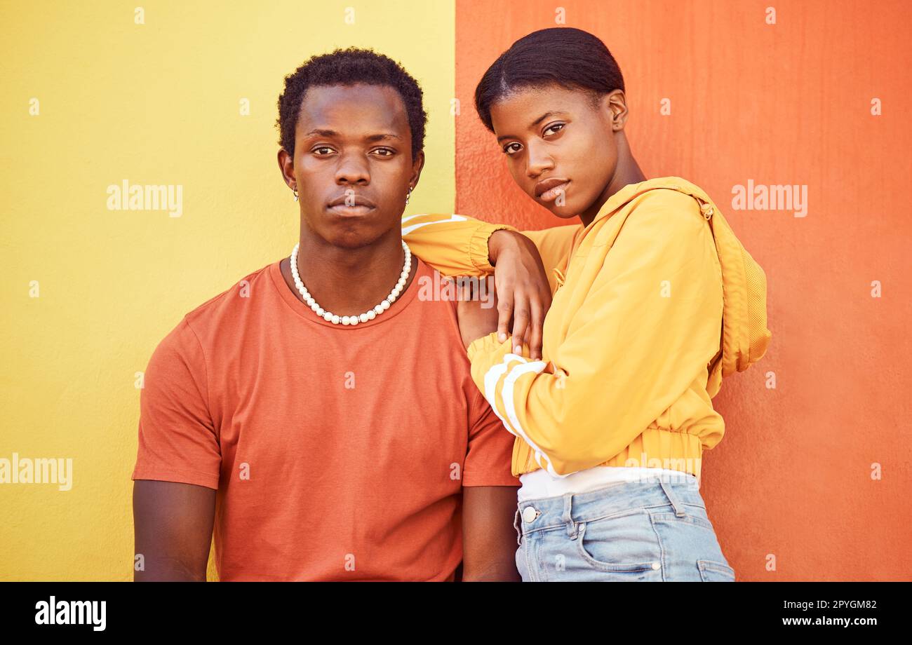 Fashion portrait of African couple, people or friends relax with designer brand clothes, casual style and luxury apparel. Urban gen z aesthetic, black woman and man on orange yellow background wall Stock Photo