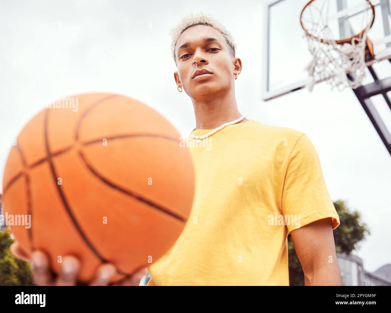 Sports, basketball court and a portrait of man with ball outside at park. Exercise, motivation and workout for fitness, wellness and health. Street game, outdoor basketball training and serious face. Stock Photo