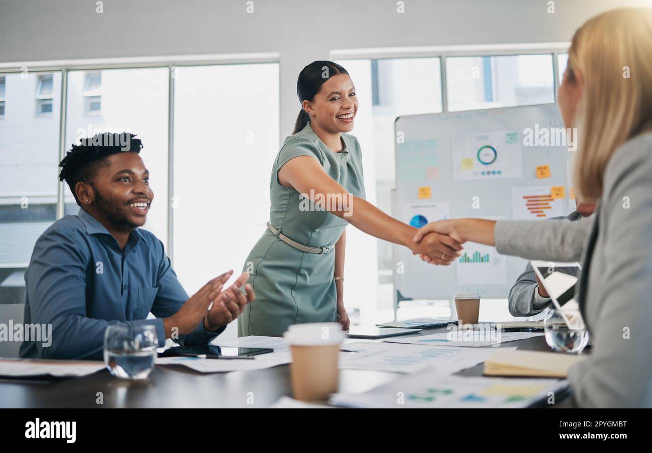 Business people, woman and handshake at meeting, planning and chart on board for target, success or goal. Corporate finance group, applause and celebration for profit, promotion or vision in New York Stock Photo