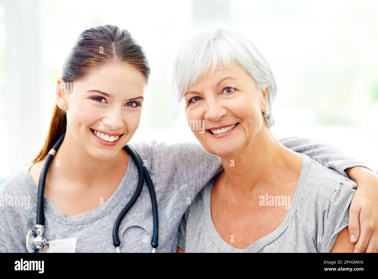 Shes a model patient. A caring healthcare practitioner with her arm around a senior patient. Stock Photo
