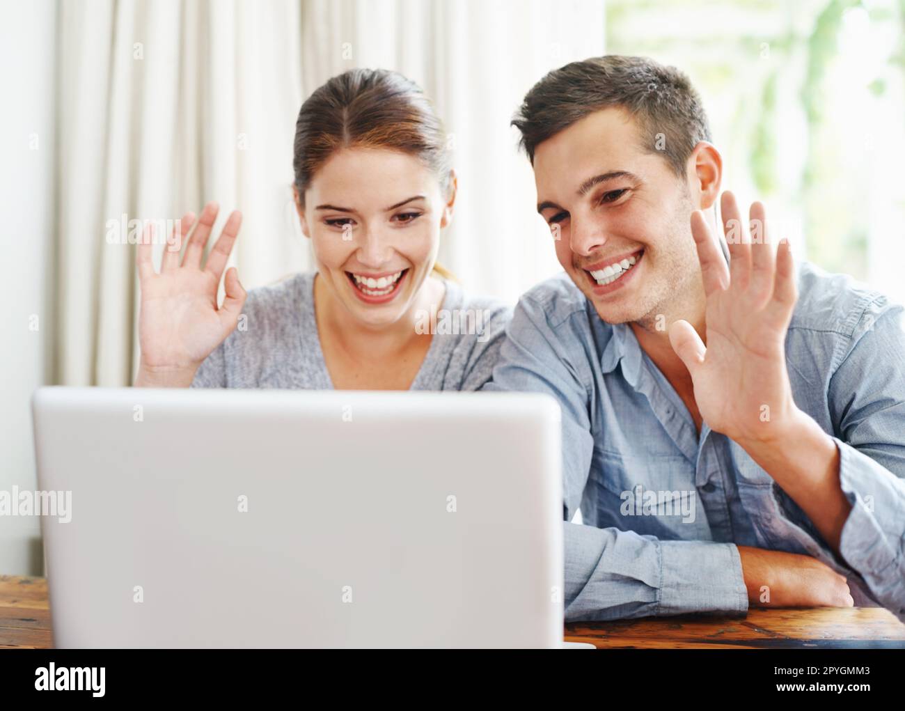 Its been great chatting. A happy young couple on a video call with some relatives. Stock Photo