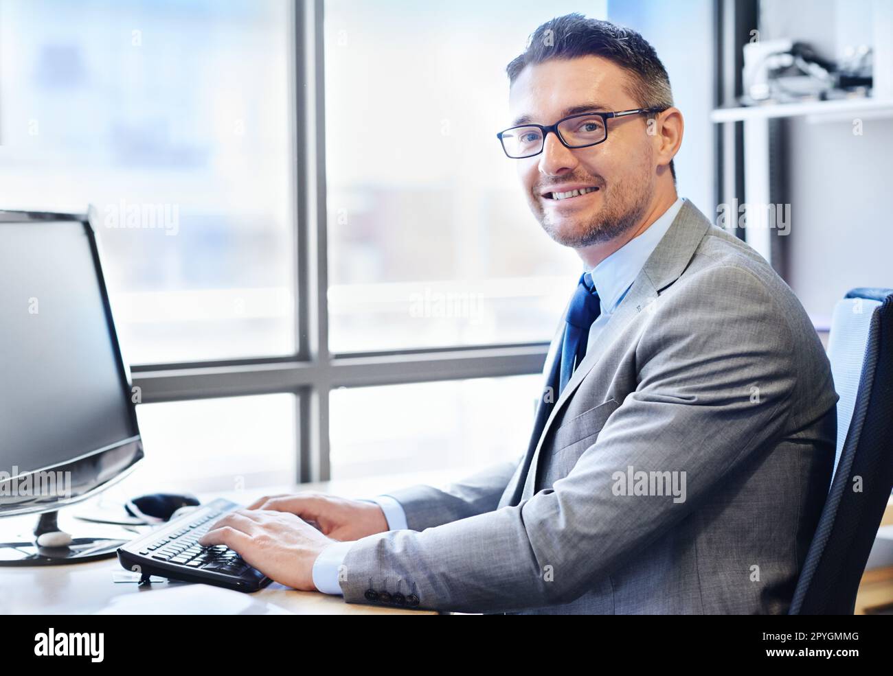Hes got a great work ethic. Portrait of a smiling businessman at work in his office. Stock Photo