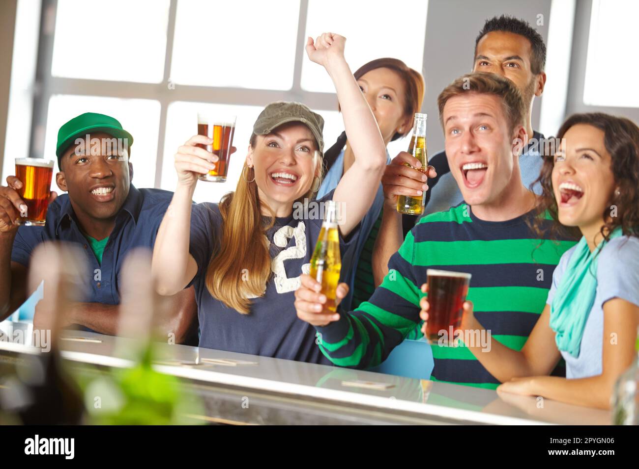 Fans to the end. A group of excited friends cheering on their favourite team at the bar. Stock Photo