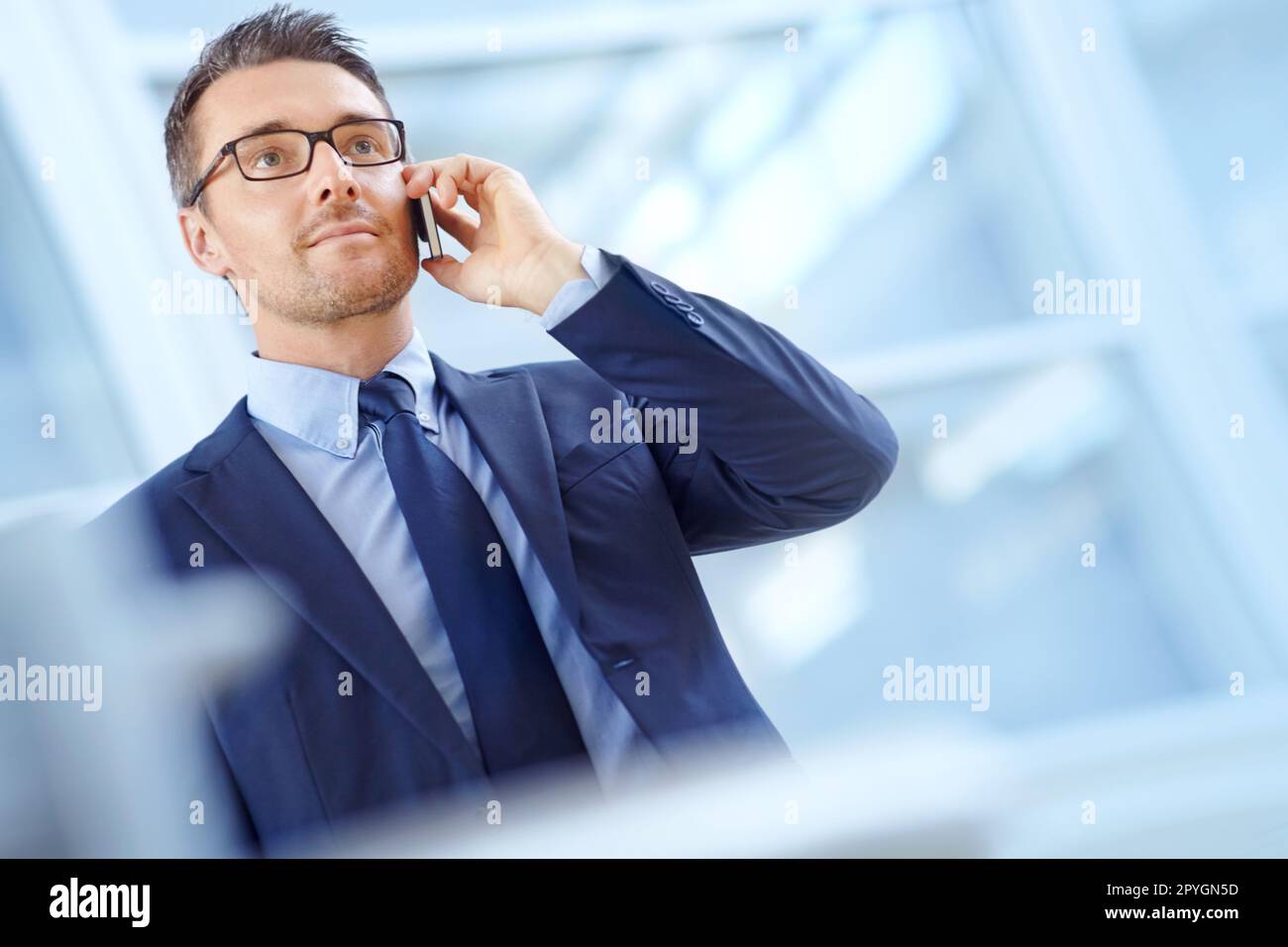 Taking a corporate call. Handsome mature businessman on his mobile while looking away. Stock Photo