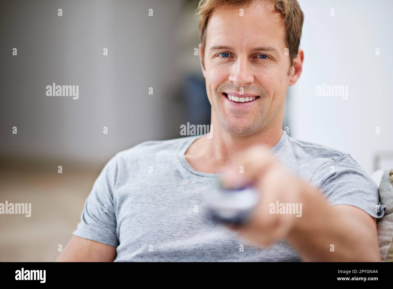The life of a bachelor. a handsome man holding a remote control. Stock Photo
