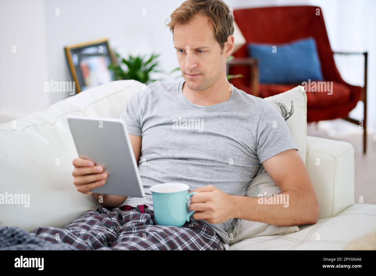 Rest and relaxation...a handsome man drinking coffee while using his