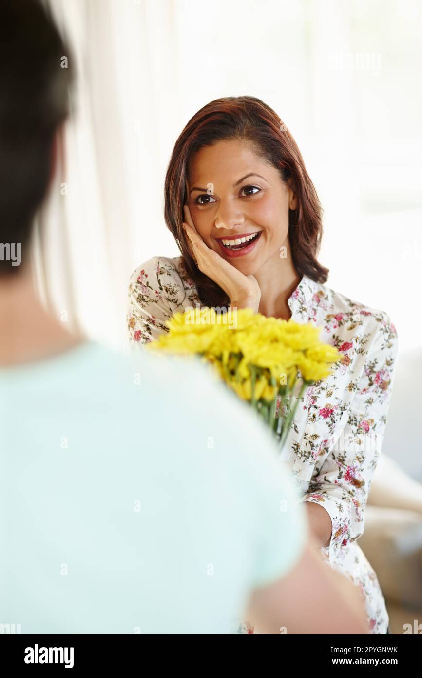 You remembered. A delighted young woman receiving flowers from her boyfriend. Stock Photo
