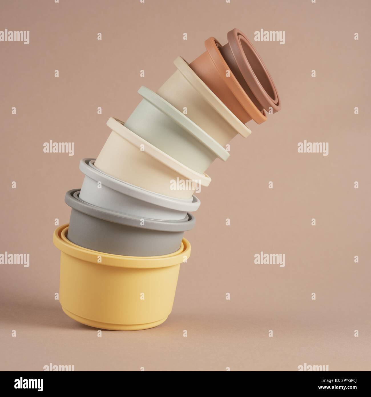 Set of cute pastel silicone bowls of different size for water game and play with sand stacked in column. Instagram use. Stock Photo