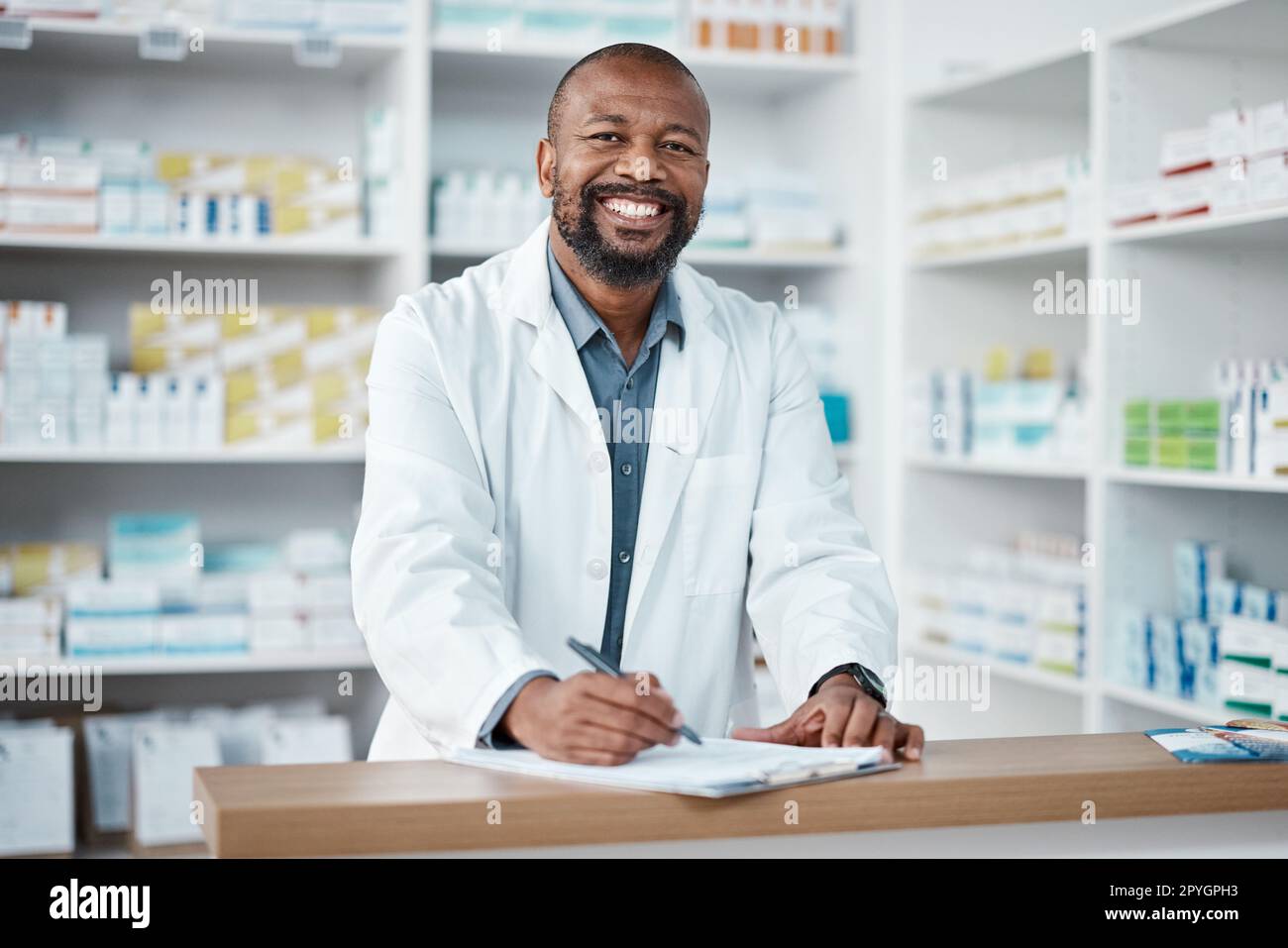 Pharmacy, portrait and black man with clipboard, medicine and pill prescription. African American male, pharmacist and medical professional writing, make notes for stock and inventory for healthcare. Stock Photo