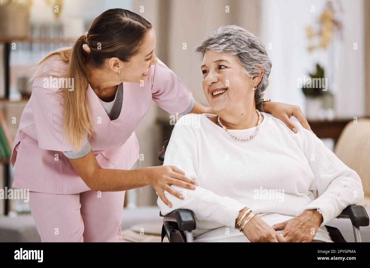 Healthcare, support and caregiver with senior woman for medical help, elderly care and consulting patient. Wheelchair disability, rehabilitation and nurse volunteer at nursing home for charity work Stock Photo