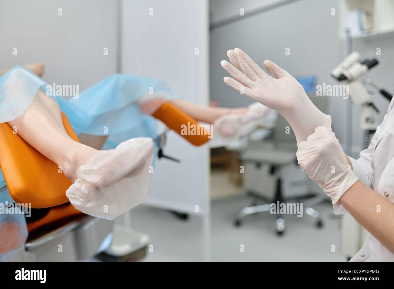 Doctor gynecologist wearing sterile rubber preparing for examination