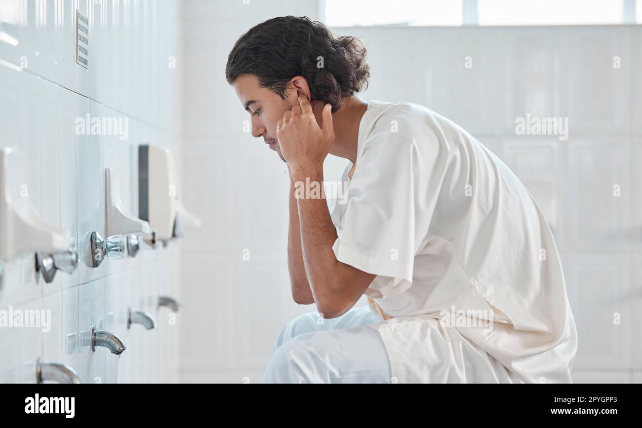 Islam, ablution and man washing before prayer in bathroom at mosque in Iran, spiritual cleaning ritual. Islamic culture, water and worship, muslim guy in cleansing care routine to prepare for praying Stock Photo