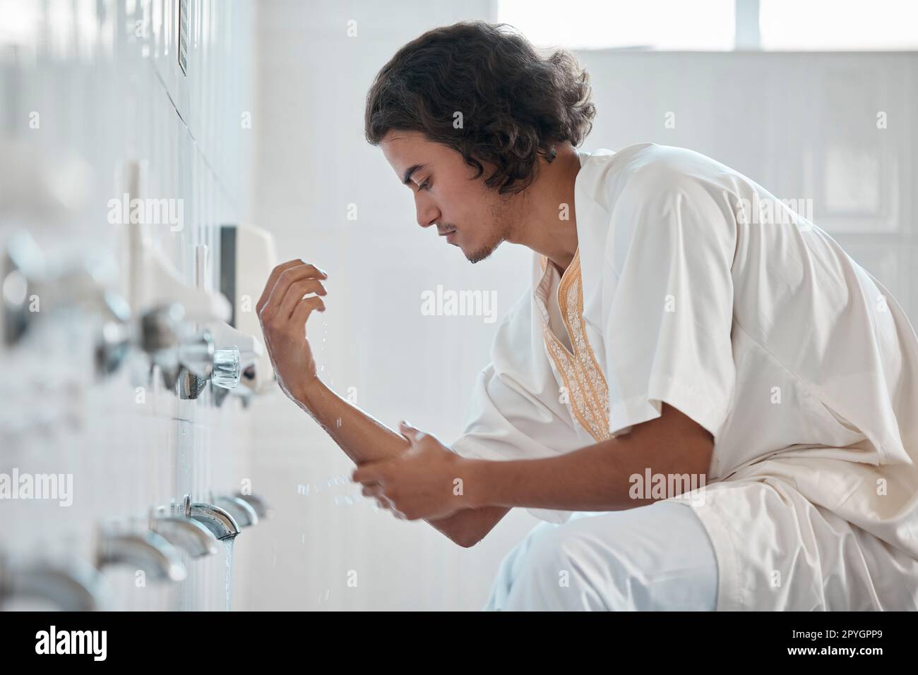 Islam, ablution and man washing before prayer in bathroom at mosque in