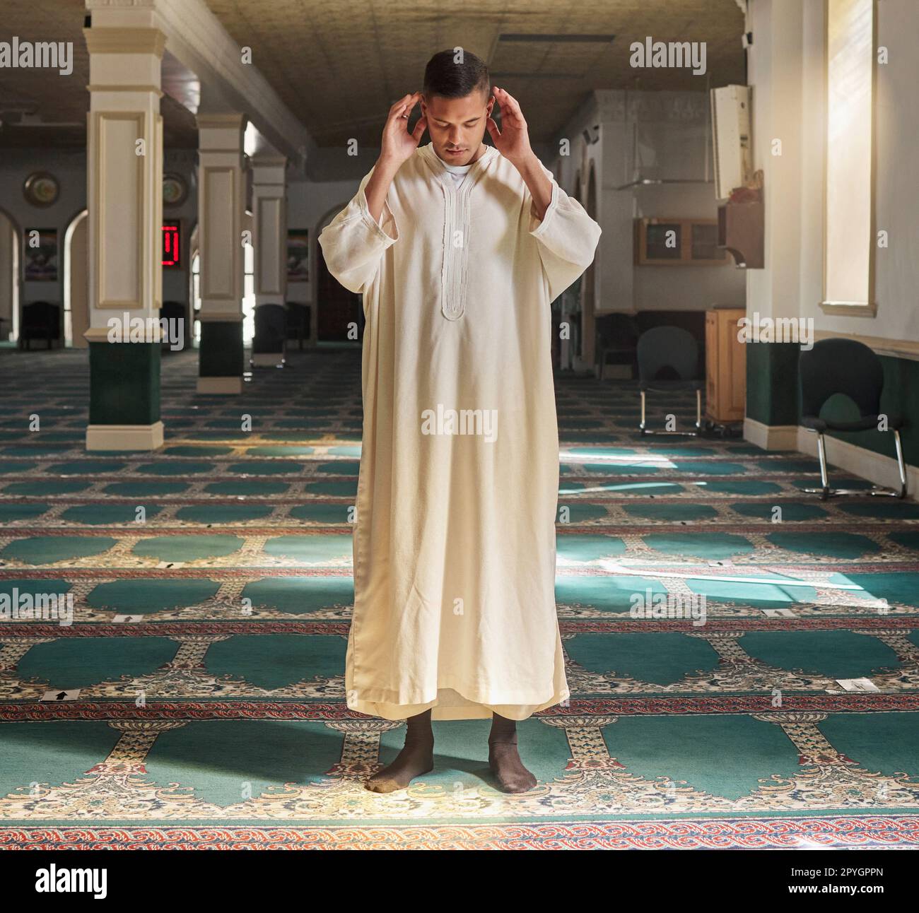 Muslim, prayer or man in a mosque praying to Allah for spiritual mindfulness, support or wellness in Doha, Qatar. Religion, peace or Islamic person in temple to worship or praise God with gratitude Stock Photo