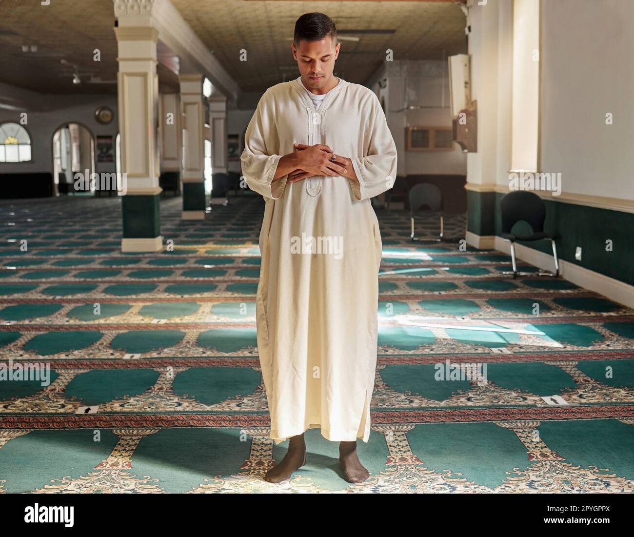 Man, muslim faith and praying in mosque for God, peace and mindfulness with traditional islamic clothes. Islam worship, prayer and spiritual balance for ramadan, religion and gratitude in Doha, Qatar Stock Photo