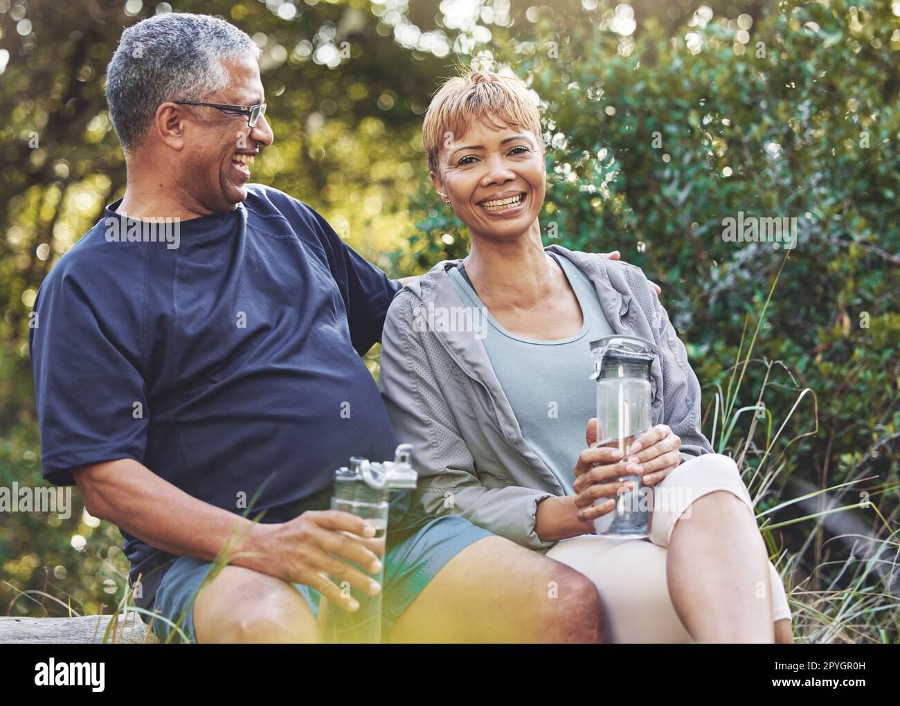 Fitness, portrait or old couple in nature for hiking workout, walking exercise or trekking on holiday vacation. Retirement, healthy or happy woman hugs or bonding with senior partner in a forest park Stock Photo