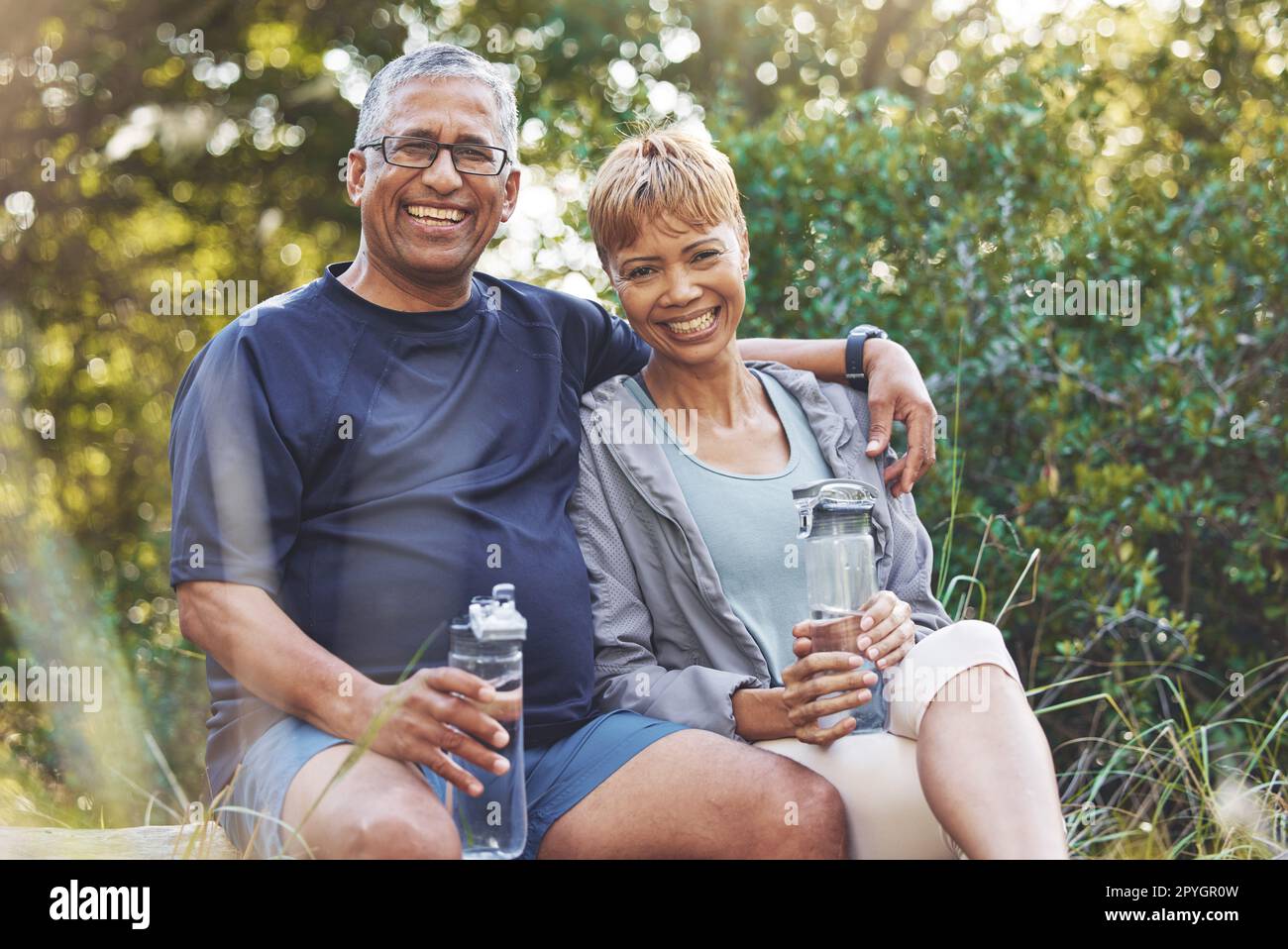 Nature, hiking and portrait of a senior couple resting while doing outdoor walk for exercise. Happy, smile and elderly man and woman in retirement trekking together for wellness in a forest in Brazil Stock Photo
