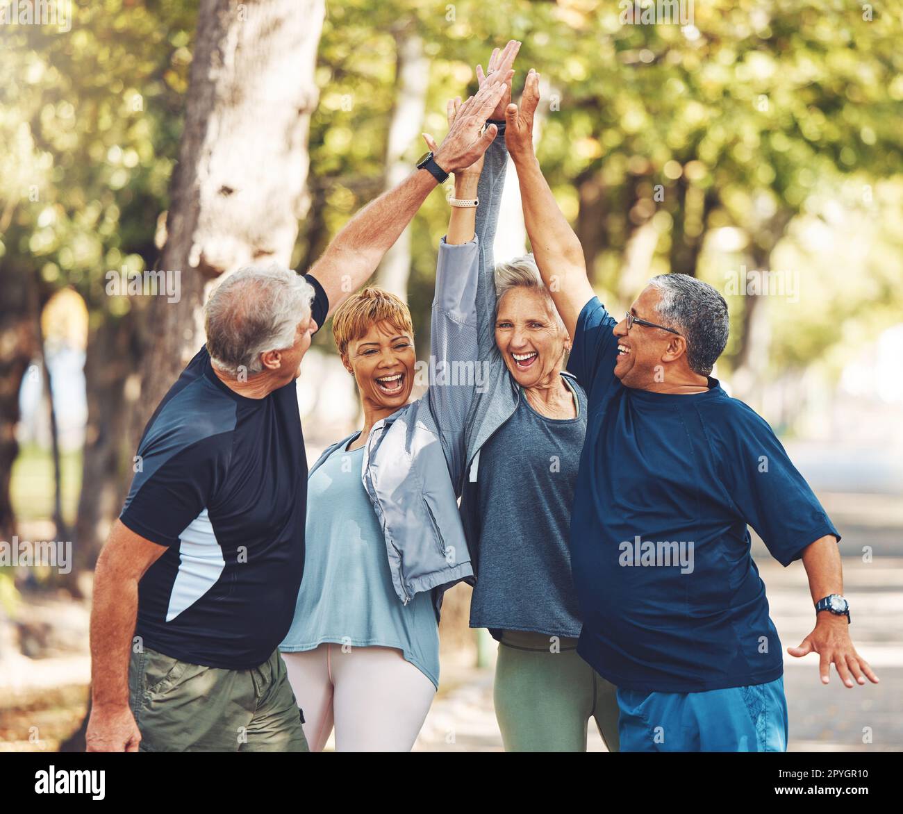 Happy, senior or people high five for fitness training goals, workout target or exercise achievement in nature. Healthy, partnership or excited elderly men and women in celebration of group teamwork Stock Photo