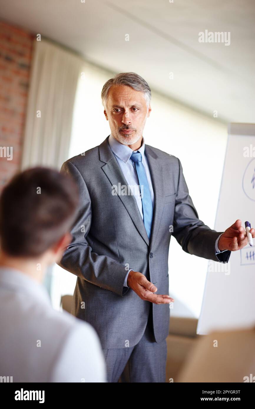 Putting him on the spot. A cropped shot of a confident mid adult man making a presentation at work. Stock Photo