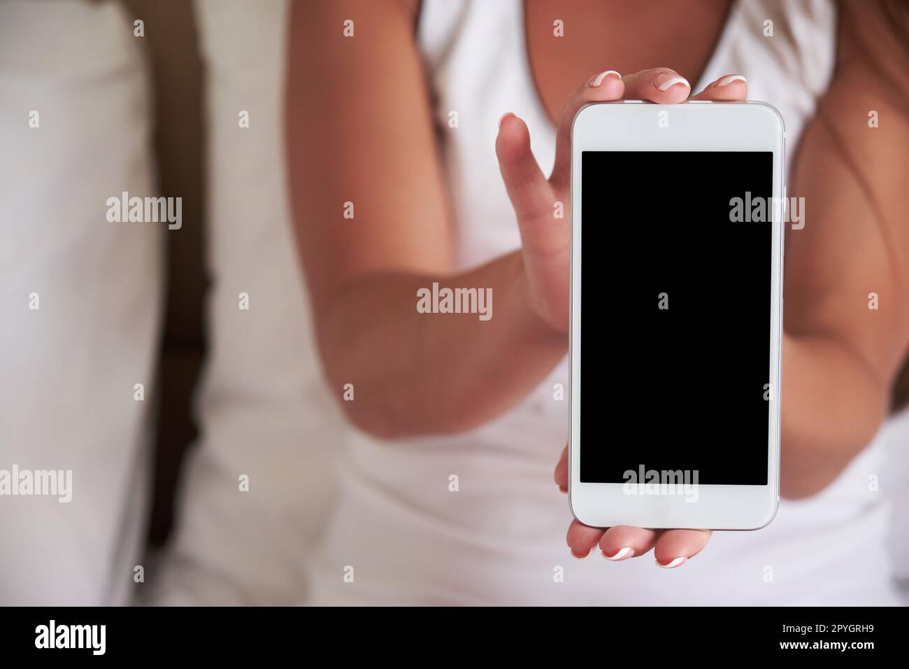 Smartphone with a blank screen in a woman's hand. Template for Design. Stock Photo