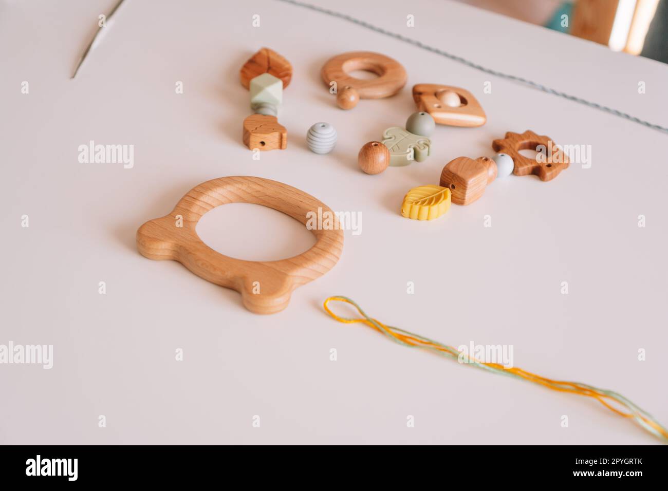 Ecological teether toy for toothache on desk. Natural safe accessories of wood. Haptic healthcare baby pacifiers Stock Photo