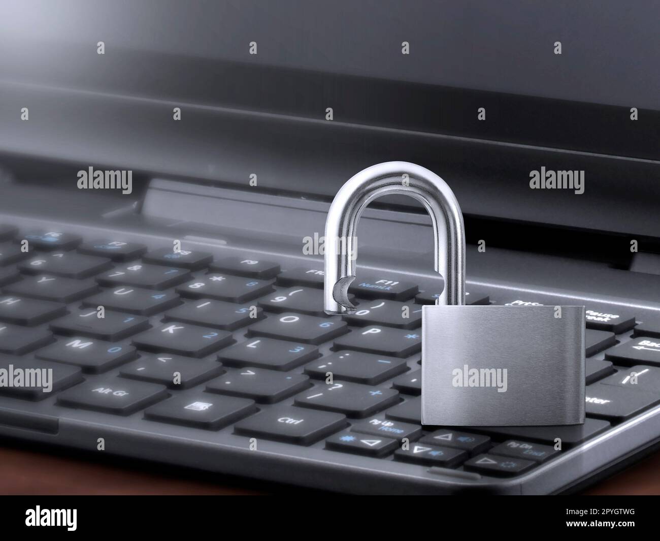 Computer security concept. Unlocked padlock on laptop keyboard. Stock Photo