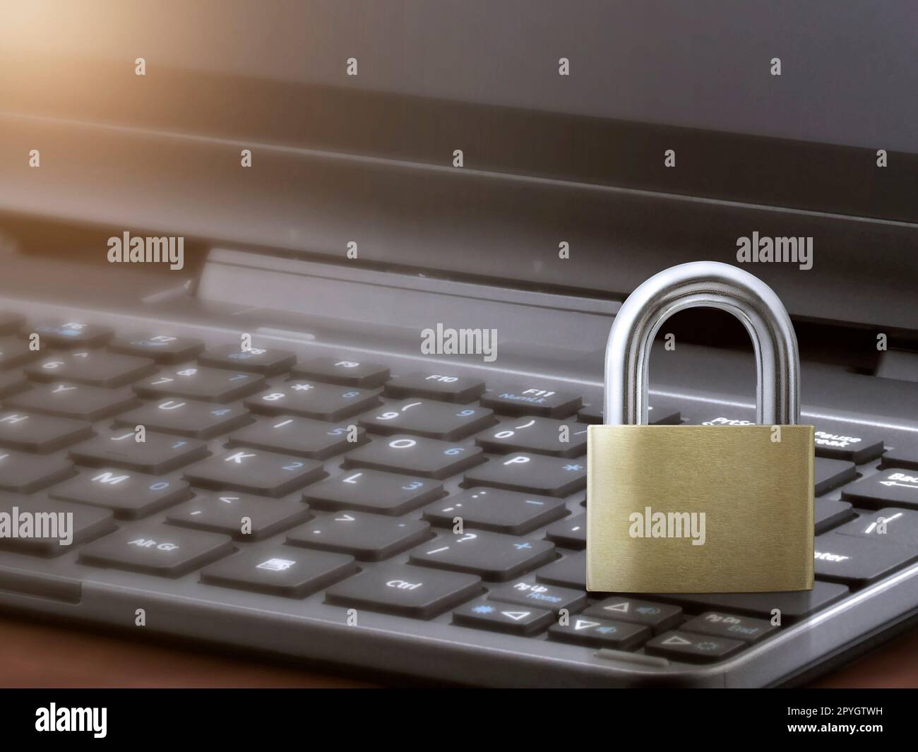 Computer security concept. Unlocked padlock on laptop keyboard. Stock Photo