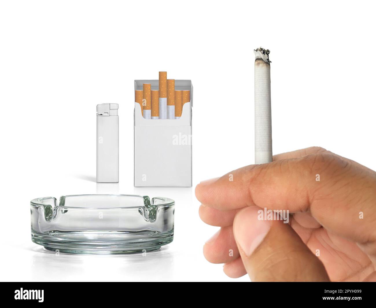 A cigarette in a hand, Cigarette pack, ashtray, and lighters isolated