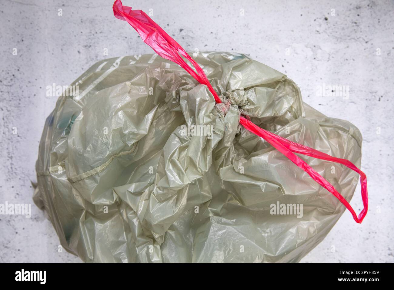 green plastic garbage bag for plastic waste, ready to recycle, waste management top view Stock