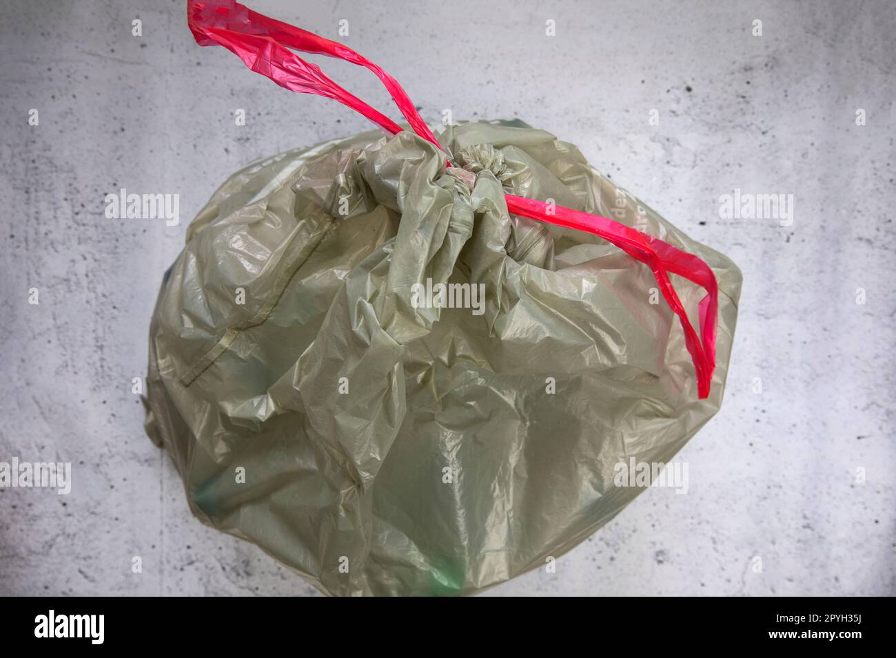 green plastic garbage bag for plastic waste, ready to recycle, waste management top view Stock
