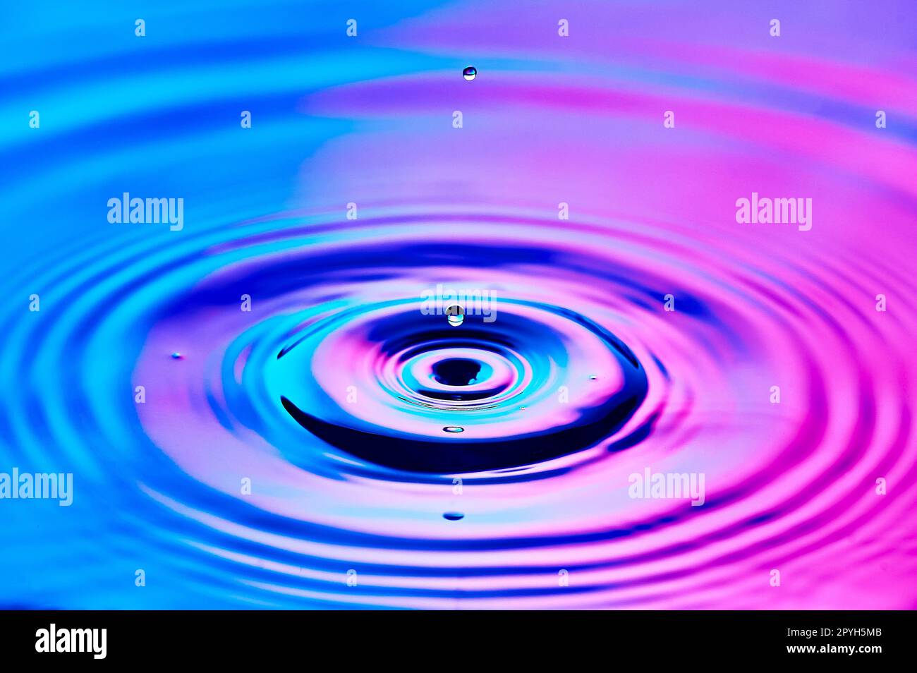 a drop of water falling into the water and creating waves Stock Photo ...