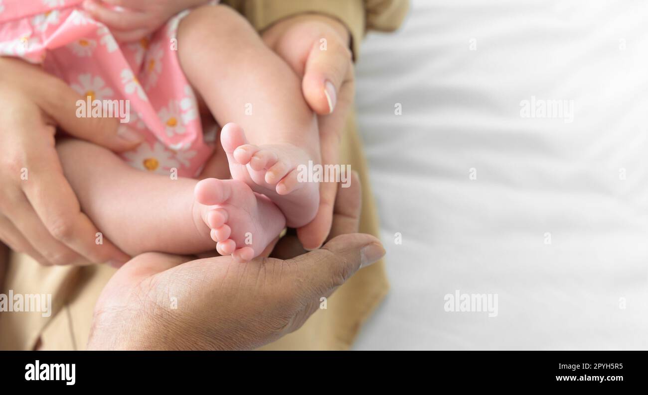 Newborn baby feet in hands of mother and father Stock Photo