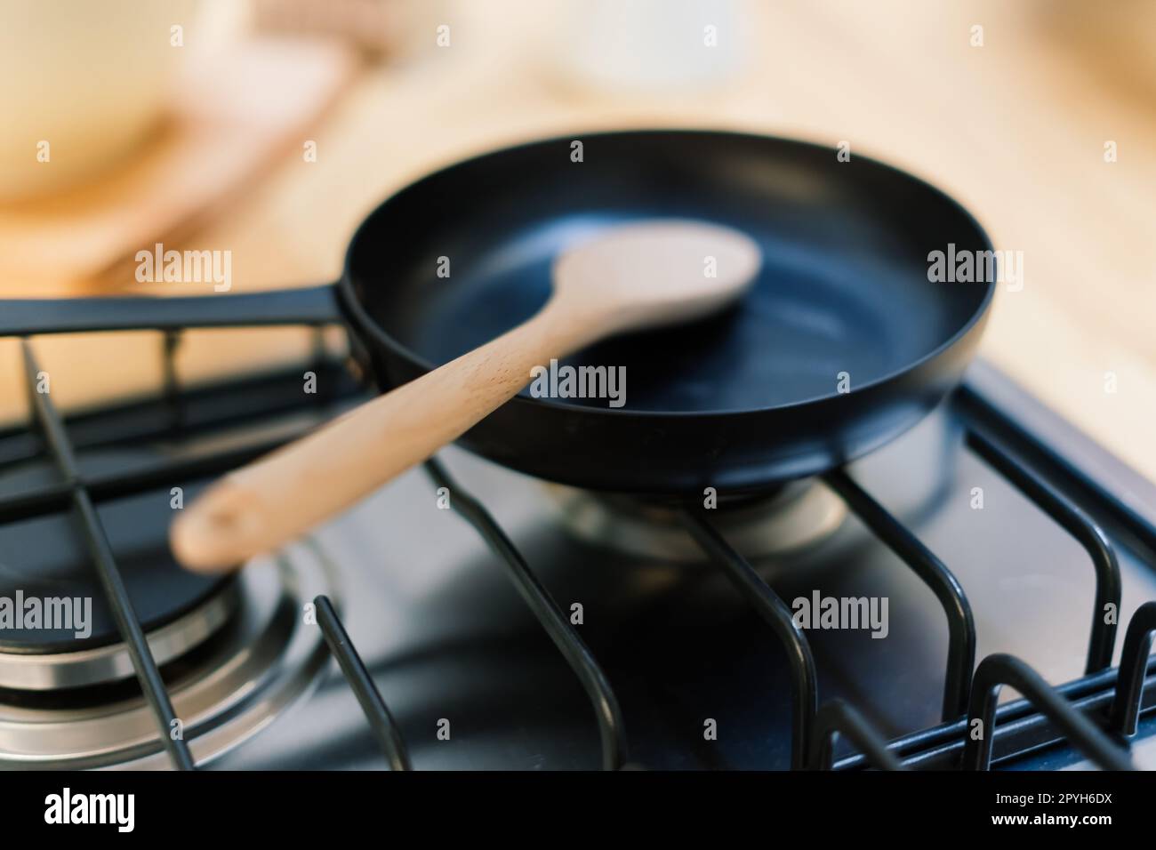 Spatula in skillet teflon coating pan on gas stove against spoon