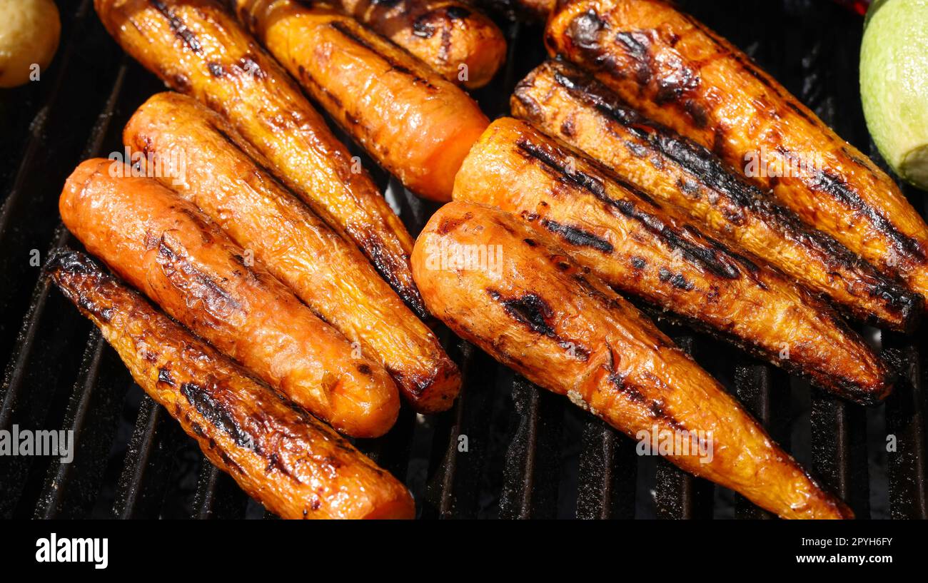 Cooking new carrots in charcoal grill Stock Photo Alamy