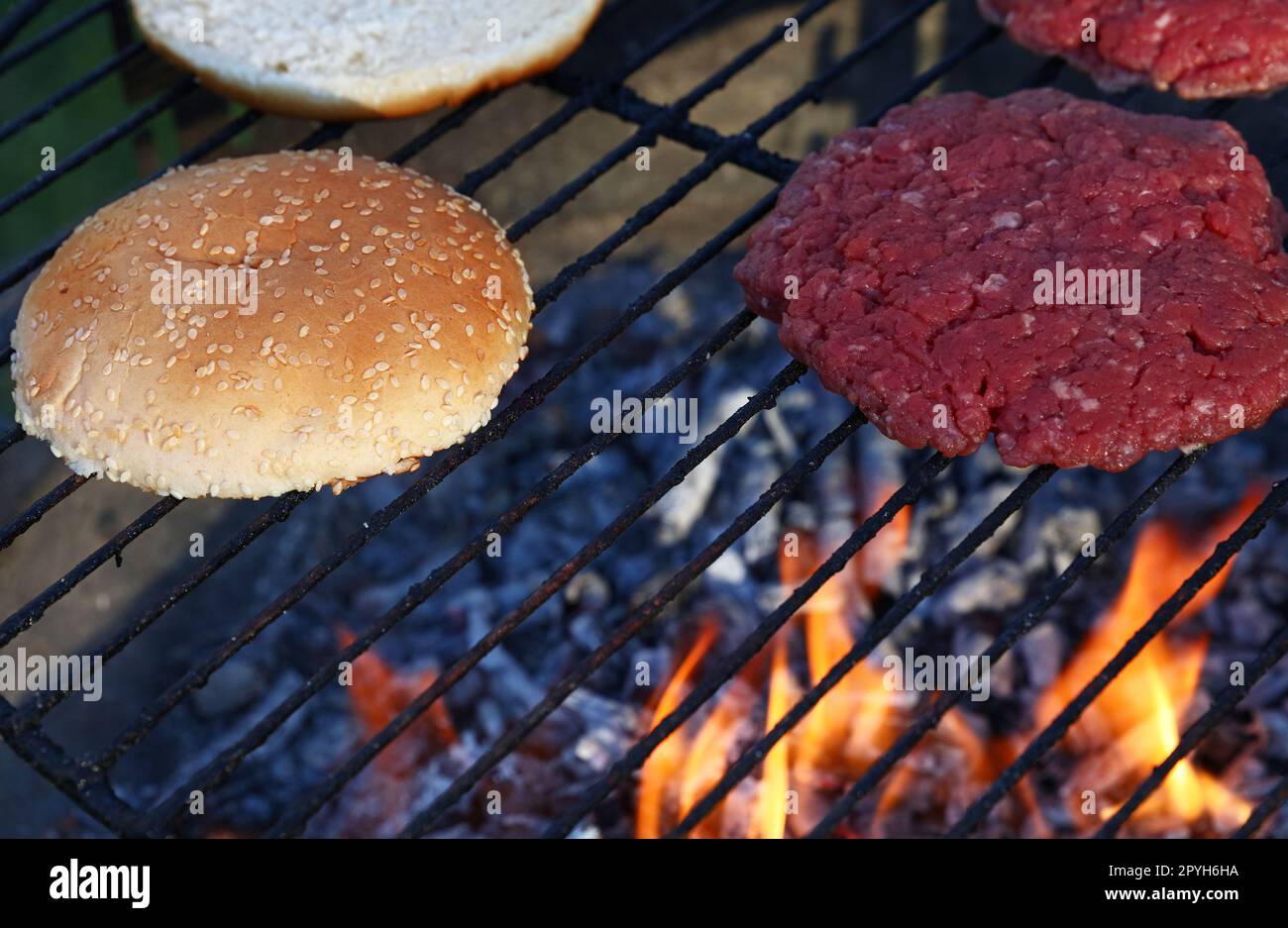 Meat burgers and buns for hamburger on fire grill Stock Photo Alamy