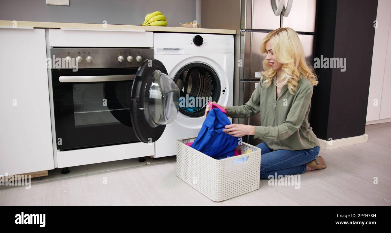 Woman Loading Dirty Clothes In Washing Machine For Washing Stock Photo