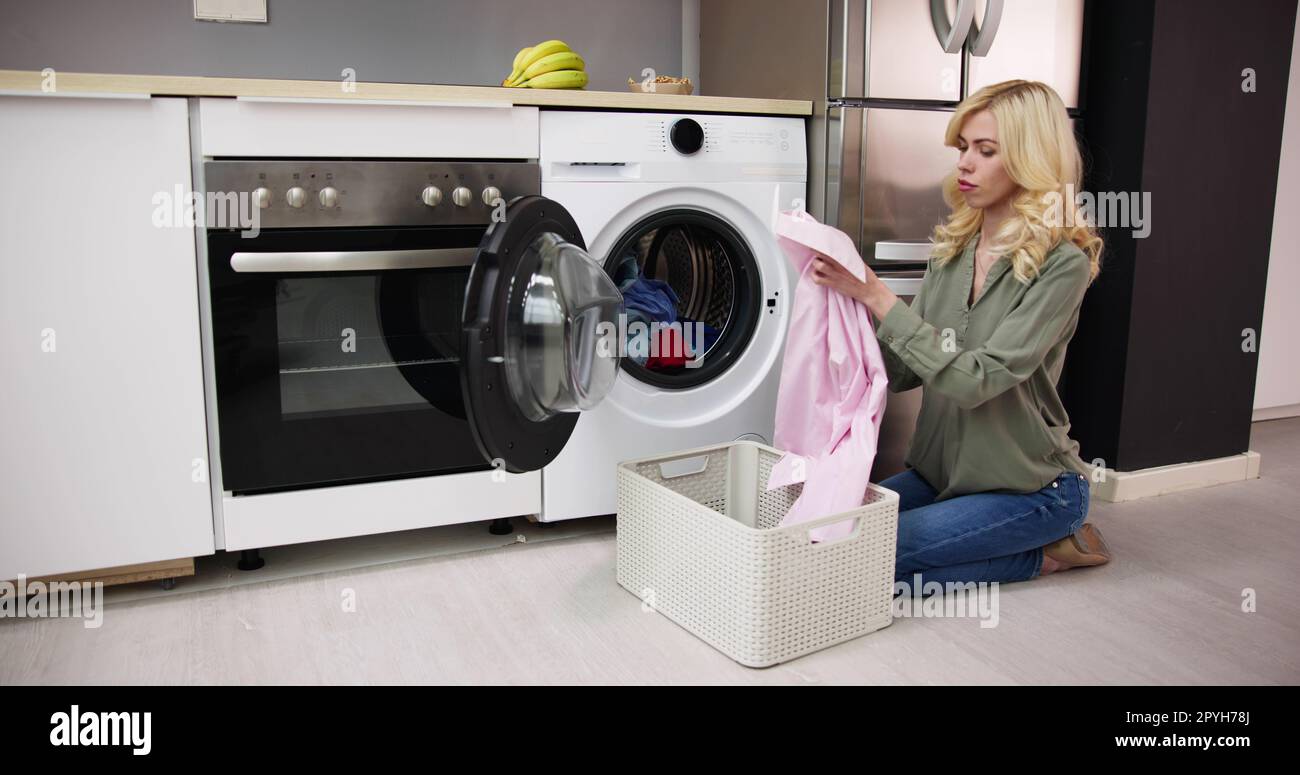 Woman Loading Dirty Clothes In Washing Machine For Washing Stock Photo