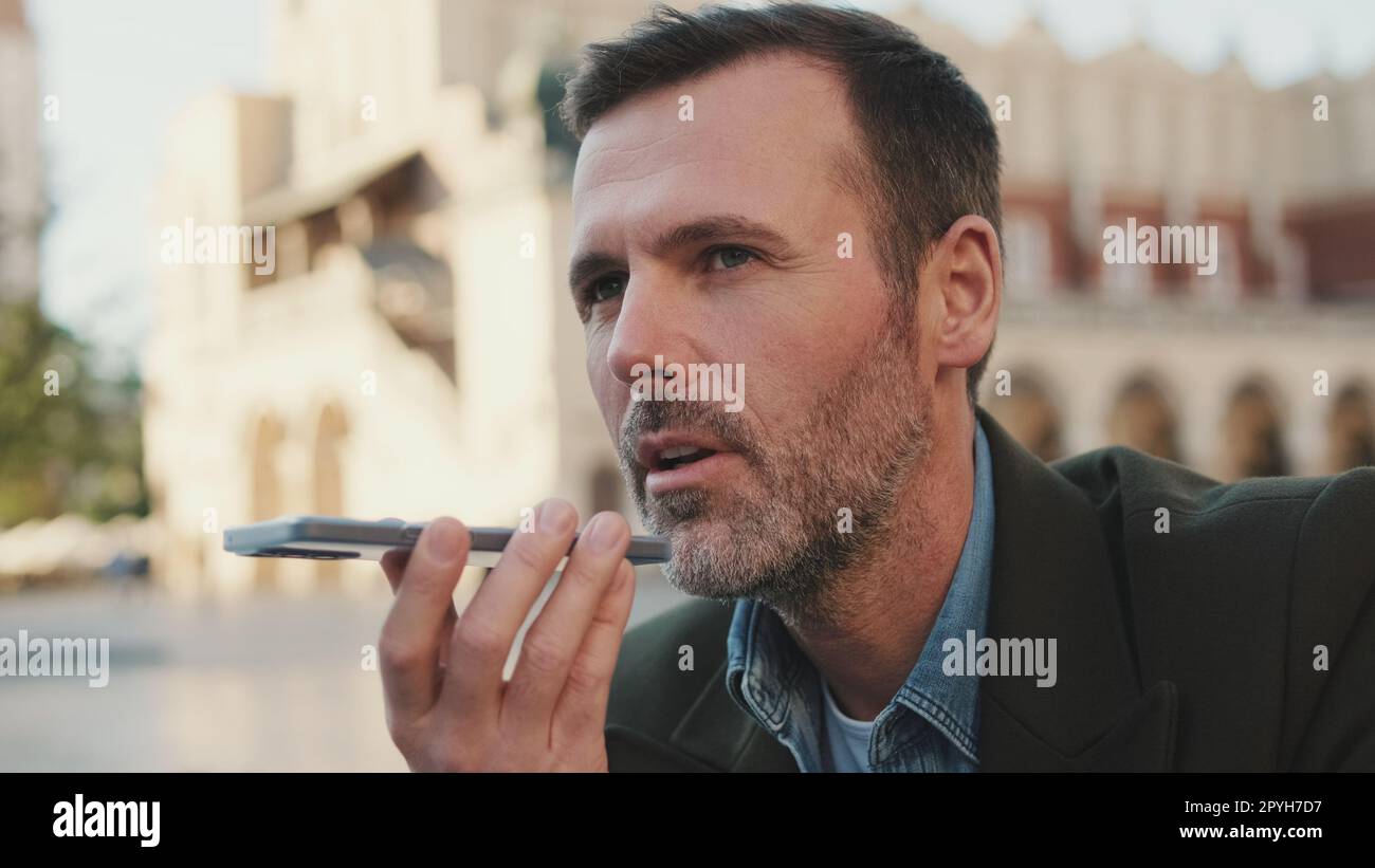 Man sends voice message on old town background Stock Photo